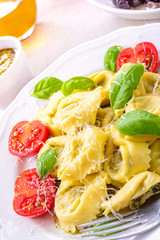 ravioli with spinach filling, grated cheese and cocktail tomatoes