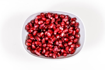Pomegranate seeds close up on white background