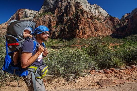 A man with his baby boy are trekking in Zion national park, Utah, USA