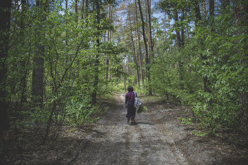 Naklejka na ściany i meble Girl walking in coniferous forest at summer.