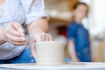 pottery workshop. handmade craft. artisan forming and shaping clay on potter wheel