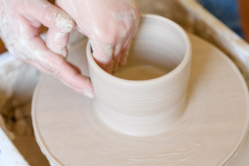 pottery workshop. handmade craft. artisan forming and shaping clay on potter wheel