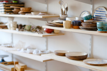 Naklejka na ściany i meble pottery business. handicraft handmade production. assortment of craft crockery and clay plates on shelves in workshop
