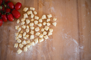 ingredients for gnocchi: flour, potatoes, an egg and tomatoes for the sauce