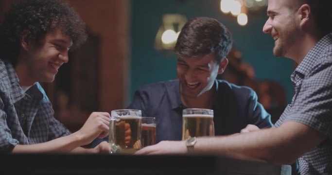 friends doing highfive then drinking beer in pub 4k dollyshot