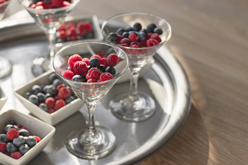 Berries of blueberries, raspberries in a beautiful vase on the table