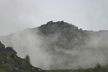 High mountain surrounded by myst. This mountain is located in a small town in italy