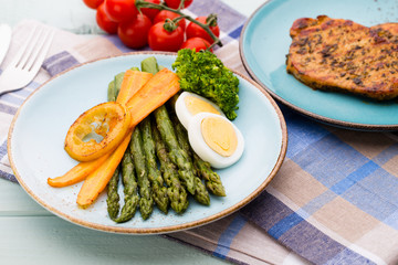 Fried asparagus with broccoli and lemon and carrot.