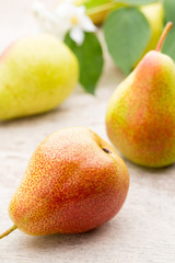Fresh pears with leaves in a on wooden background.