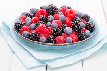 Fresh raspberries in a plate on a  vintage background.