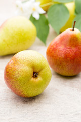 Fresh pears with leaves in a on wooden background.