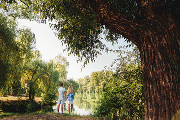 Fototapeta premium Rear view of couple looking at lake in park