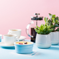 Berry clafouti. Traditional french sweet fruit dessert clafoutis with raspberries and blueberries on blue pink background. Healthy gluten free food concept with copy space.