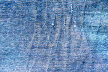 Texture of a fabric of a blue piece of jeans trousers