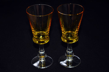 glasses of whiskey wine vodka transparent yellow stack on black background