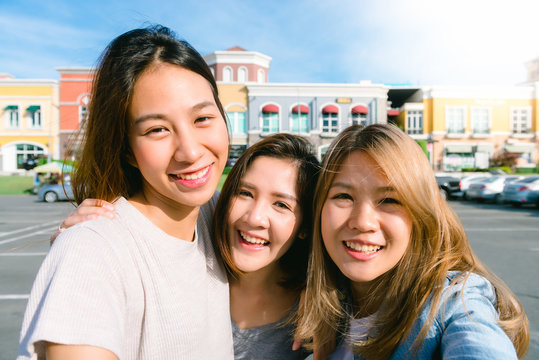Close up of young Asian women group selfie themselves in the pastel buildings city in nice sky morning. City lifestyle of young women group on weekend. Outdoor shopping and city lifestyle concept.