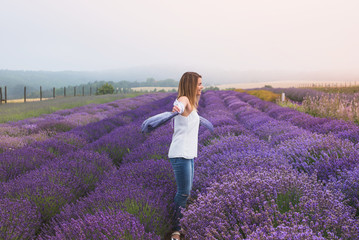 Beautiful young woman is dancing on the lavender field