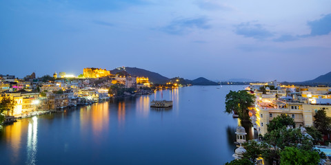Fototapeta na wymiar Udaipur city at lake Pichola in the evening, Rajasthan, India. View of City palace reflected on the lake.