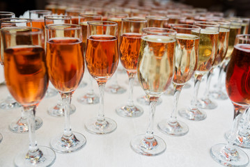 Many wine glasses with a cocktail on the white table.