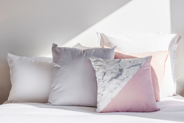 Fototapeta na wymiar Pink and white pillows on a bed arrangement with copy space