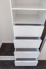 Set of open drawers in a white cupboard