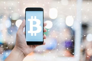 business CRYPTO CURRENCY BITCOIN  ideas concept with hand hold white blank screen smartphone with blur bokeh mall background
