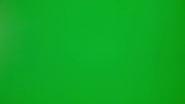 Short clip of a female hand operating a tv remote control on a green background.
