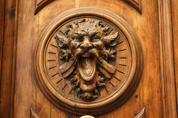 Old wooden door with carving in the form of the head of a monster with an open mouth