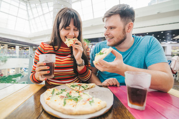 cheerful couple sitting in cafe eating pizza. hungary