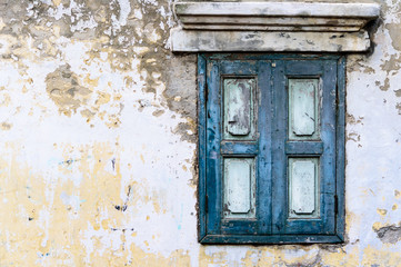 Old blue wooden window with concrete wall