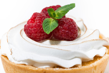 sweet tartlet with meringue and fresh raspberry on white table, selective focus