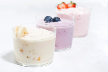 sweet yoghurts with fruits and berries on white table