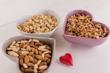 healthy brain heart food nuts in heart shape dish on white wood background 