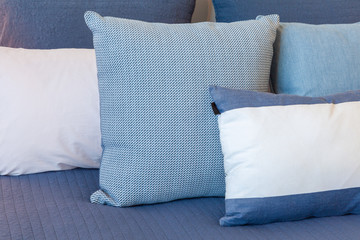 Blue and white pillows on a bed with copy space close-up