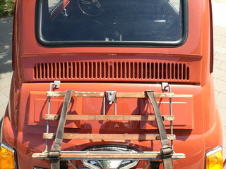 Heckgepäckträger mit Ledergurten auf der Motorhaube eines italienischen Kleinwagen Klassiker der...