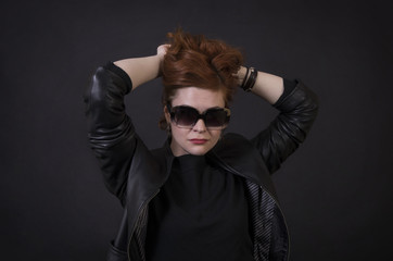 Emotional brunette posing in the Studio in a leather cloak.
