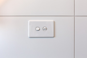 Modern double light switch on white tiles wall with copy space