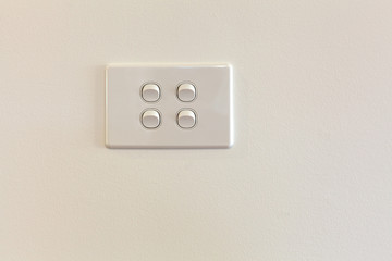 Quad modern light switch on white wall with copy space