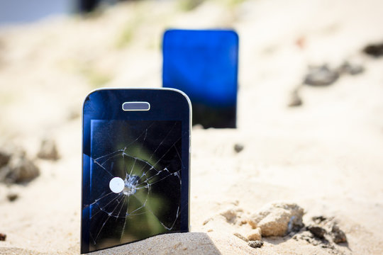A nail in an old phone, it's punched. In the background a new phone
