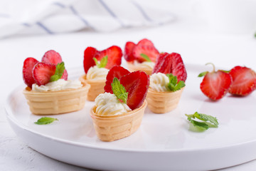Mini tartlets on the plate . Homemade dessert with delicious cream cheese and fresh berries