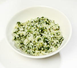 Garnish - boiled rice with herbs, close-up, on white background