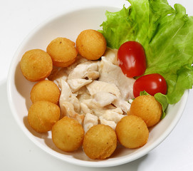 Chicken in cream sauce with potato balls, decorated with tomatoes and lettuce