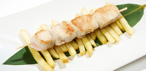 mini skewers of chicken on skewer with French fries