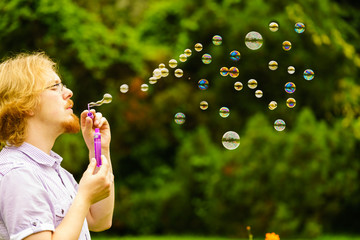 Man blowing soap bubbles outdoor