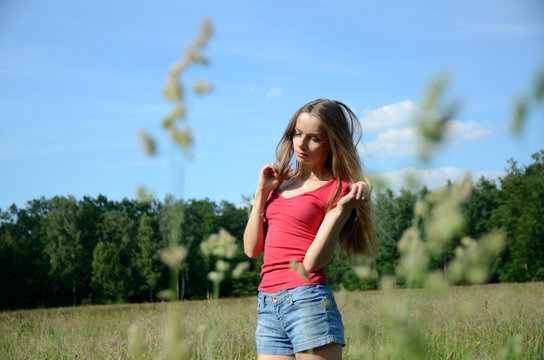 Woman with jeans shorts in the meadow