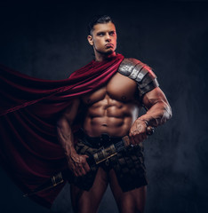 Fototapeta na wymiar Brutal ancient Greece warrior with a muscular body in battle uniforms