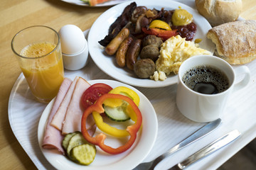Boiled eggs ,sausages, meat ball and bacon, Orange juice, Cup of black coffee, Sliced Sweet Pepper and ham on plate, healthy breakfast.
