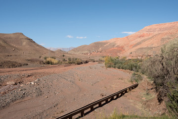 Morocco: photo of old town in sandy mountains in hot summer with blue sky 