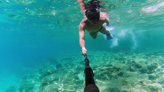 Man shooting underwater video about himself by his action camera