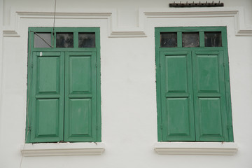 Two green windows on a white building